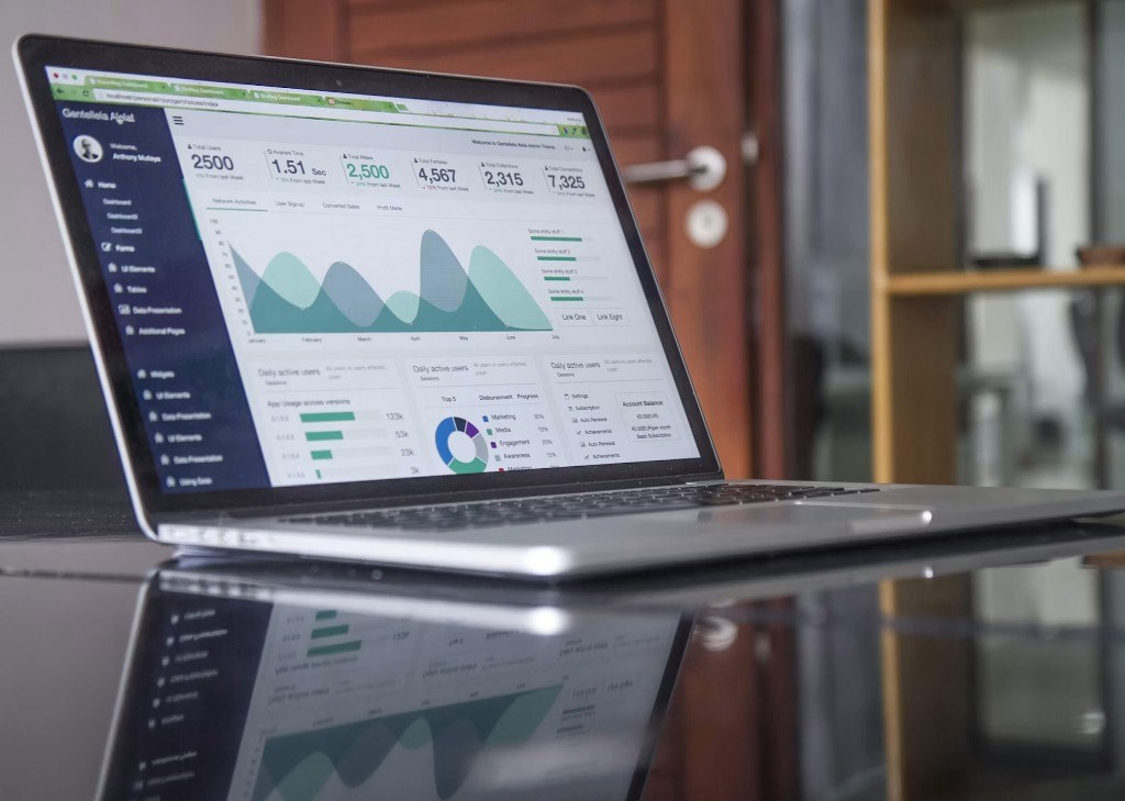 Laptop showing a RooftopXL marketing dashboard with growth metrics